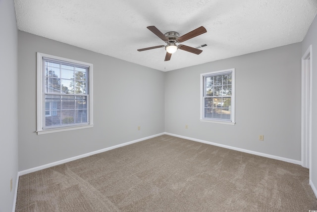 spare room with visible vents, carpet floors, and a healthy amount of sunlight