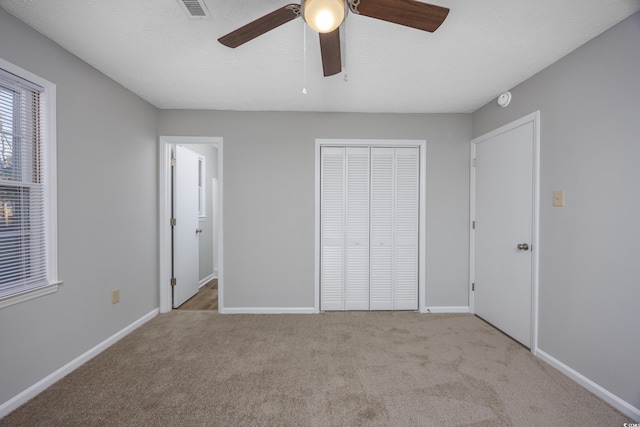 unfurnished bedroom featuring visible vents, baseboards, carpet floors, a closet, and a textured ceiling