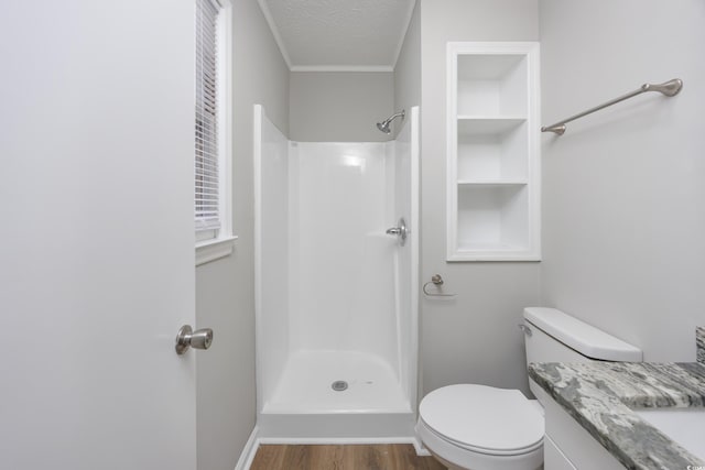 bathroom with toilet, a textured ceiling, walk in shower, and wood finished floors