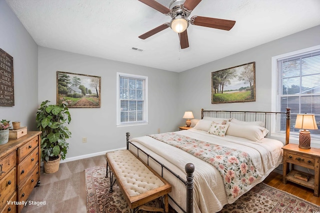 bedroom featuring a ceiling fan, baseboards, and visible vents