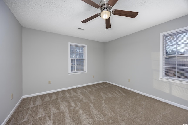 unfurnished room with visible vents, baseboards, carpet, a textured ceiling, and a ceiling fan