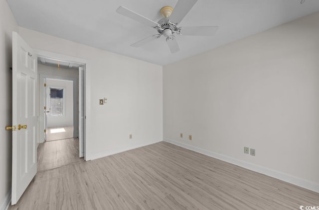 unfurnished bedroom with baseboards, attic access, ceiling fan, and light wood finished floors