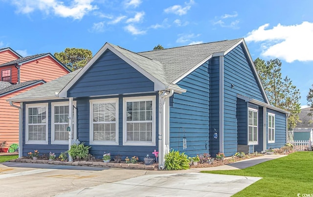 view of home's exterior featuring a yard and a shingled roof