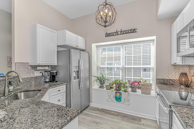 kitchen with dark stone countertops, stainless steel appliances, and a sink