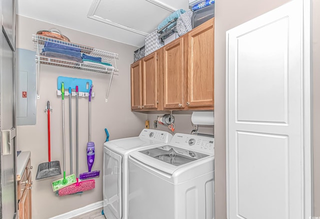 clothes washing area featuring cabinet space and independent washer and dryer