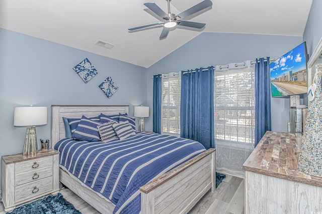 bedroom featuring lofted ceiling, light wood-type flooring, visible vents, and a ceiling fan