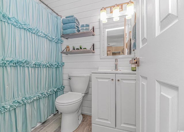 full bath featuring toilet, a shower with shower curtain, wood finished floors, and vanity