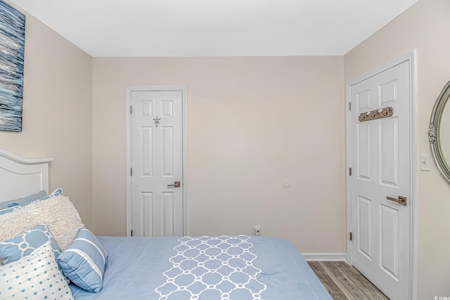 bedroom with baseboards and wood finished floors