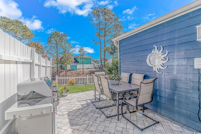 view of patio featuring outdoor dining area, a grill, and a fenced backyard