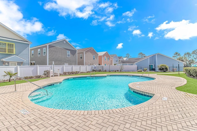 view of swimming pool with a patio, a fenced backyard, a residential view, and a fenced in pool