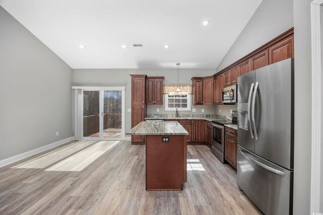 108 Silver Peak Dr, Conway, SC 29526 - kitchen featuring appliances with stainless steel finishes, lofted ceiling, a center island, light wood-style floors, and light stone countertops