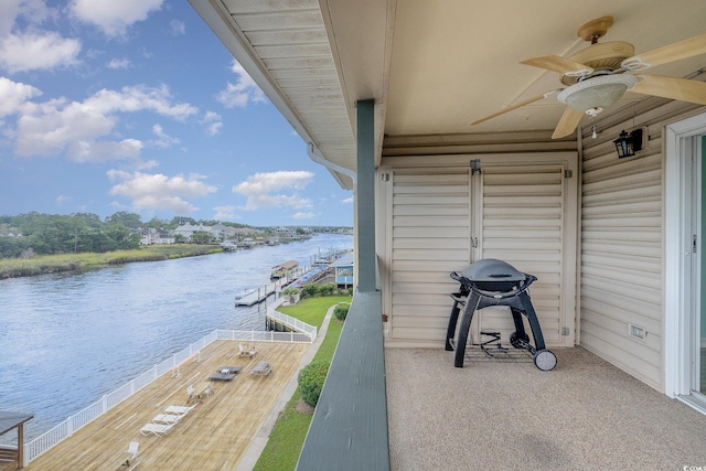 exterior space with grilling area, a water view, and ceiling fan