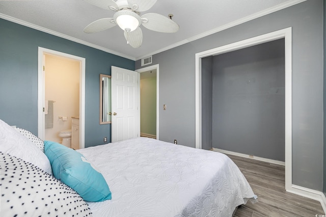 bedroom with visible vents, connected bathroom, crown molding, baseboards, and wood finished floors