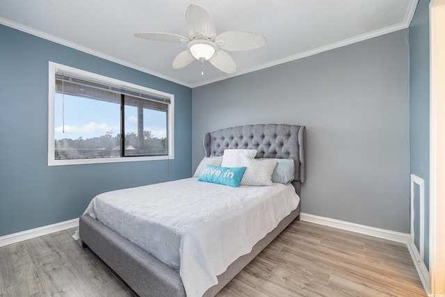 bedroom featuring ornamental molding, baseboards, and wood finished floors