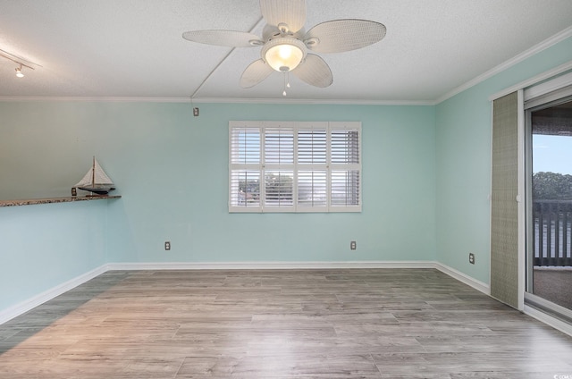 spare room with plenty of natural light, a textured ceiling, and wood finished floors