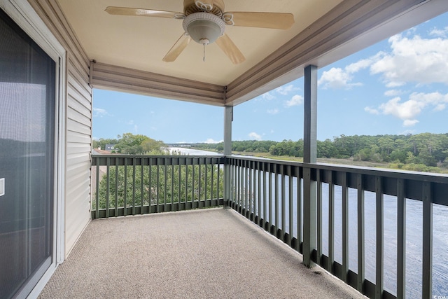 balcony with ceiling fan and a water view