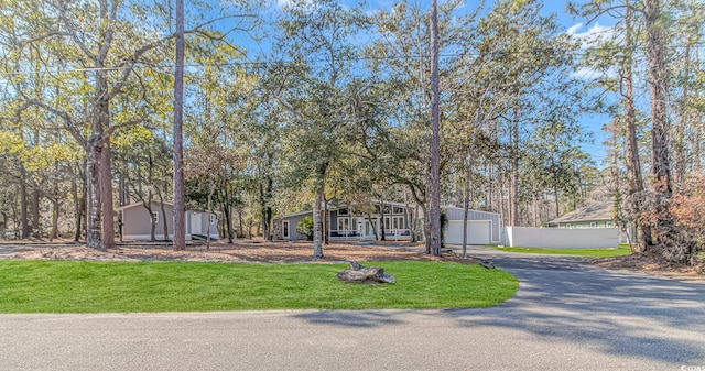 view of front facade featuring a garage, a front lawn, and fence