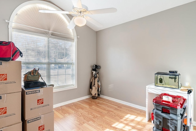 misc room with a ceiling fan, baseboards, and light wood-style floors