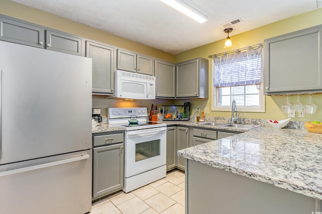 kitchen featuring a sink, visible vents, white appliances, gray cabinets, and light tile patterned floors