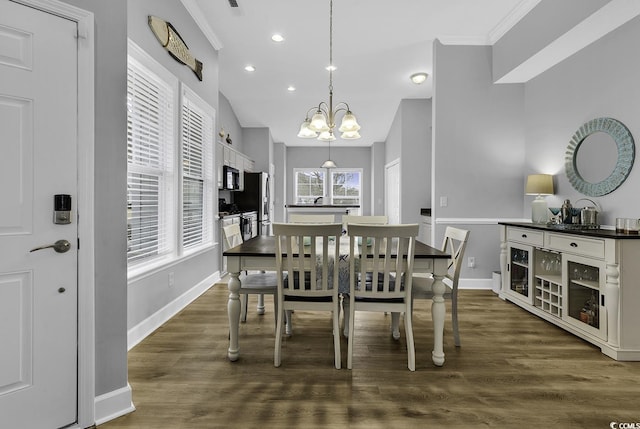 dining space with a notable chandelier, dark wood-style floors, baseboards, and ornamental molding