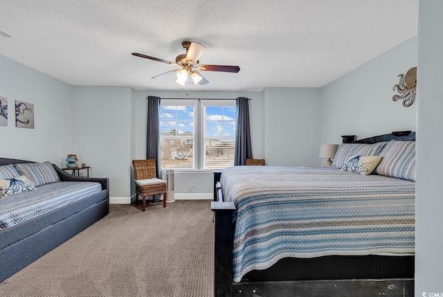 carpeted bedroom featuring a ceiling fan, baseboards, and a textured ceiling