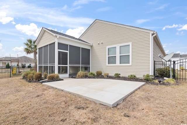 rear view of property featuring a patio area, fence, and a sunroom