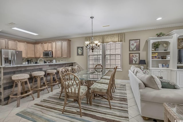 dining room featuring a notable chandelier, light tile patterned floors, baseboards, and ornamental molding