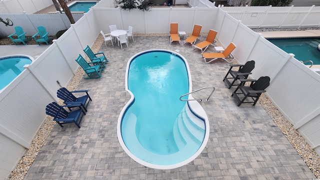 view of pool featuring a patio area, a fenced backyard, and a fenced in pool