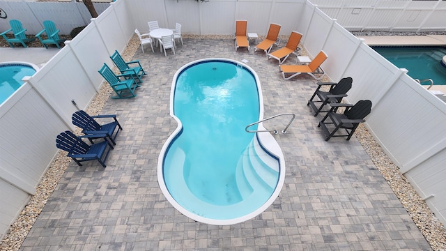 view of swimming pool with a patio, a fenced backyard, and a fenced in pool