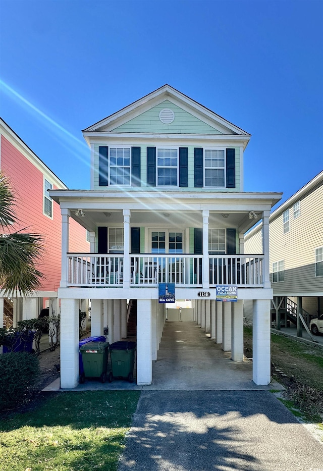 raised beach house with covered porch and driveway