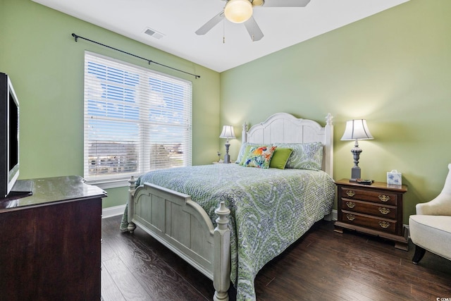 bedroom featuring dark wood finished floors, a ceiling fan, visible vents, and baseboards