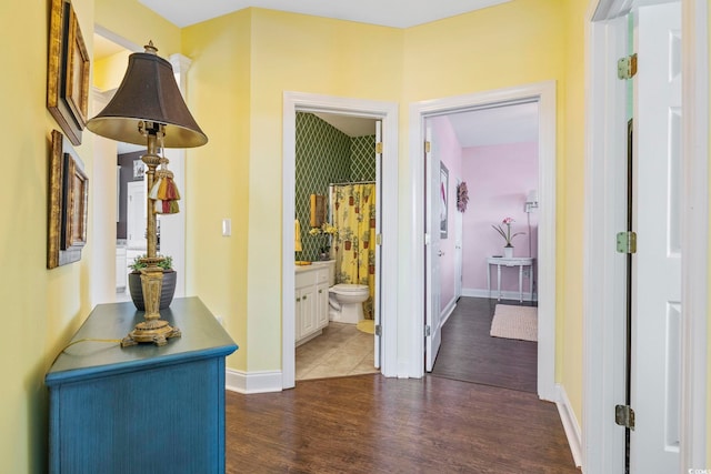 hallway with baseboards and dark wood-type flooring