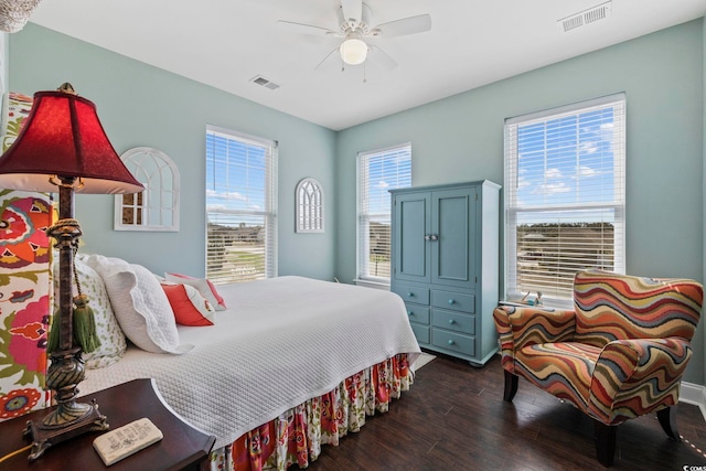 bedroom featuring a ceiling fan, visible vents, and dark wood-style flooring