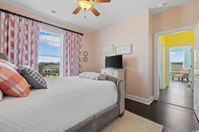 bedroom with visible vents, a ceiling fan, baseboards, and dark wood-style flooring