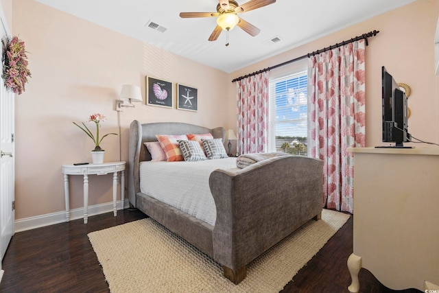 bedroom with dark wood finished floors, visible vents, ceiling fan, and baseboards