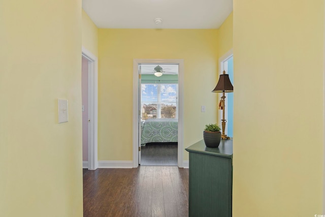 corridor with baseboards and dark wood-style floors