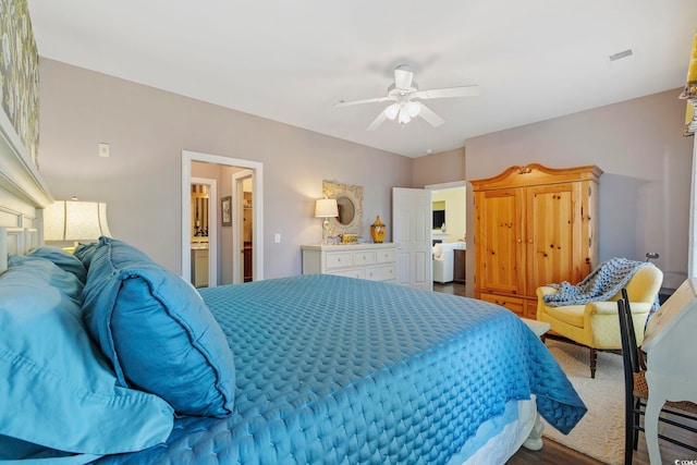 bedroom featuring ensuite bath, visible vents, baseboard heating, and ceiling fan