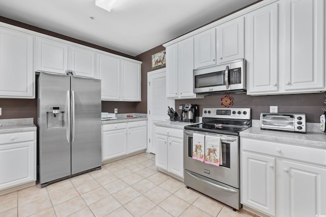 kitchen with white cabinetry, light countertops, a toaster, and appliances with stainless steel finishes