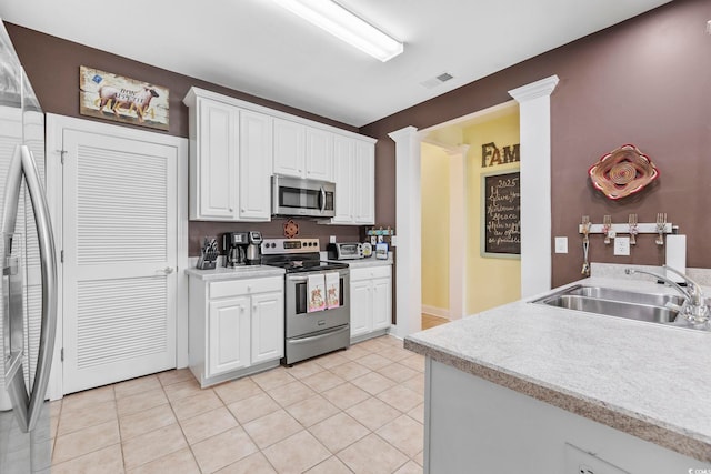 kitchen with visible vents, a sink, white cabinetry, appliances with stainless steel finishes, and light countertops