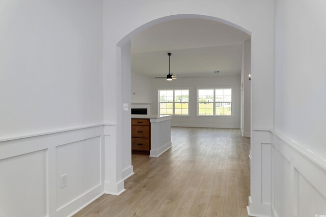 4028 Bucolic Loop, Myrtle Beach, SC 29588 - hall with arched walkways, a decorative wall, wainscoting, and light wood-style flooring