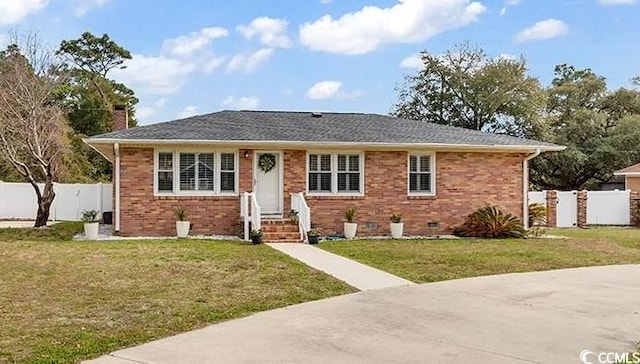 view of front of home featuring a front lawn, fence, and brick siding