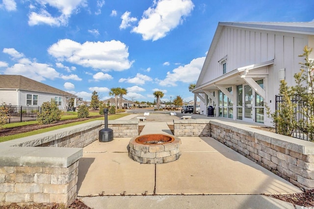 view of patio with an outdoor fire pit and fence