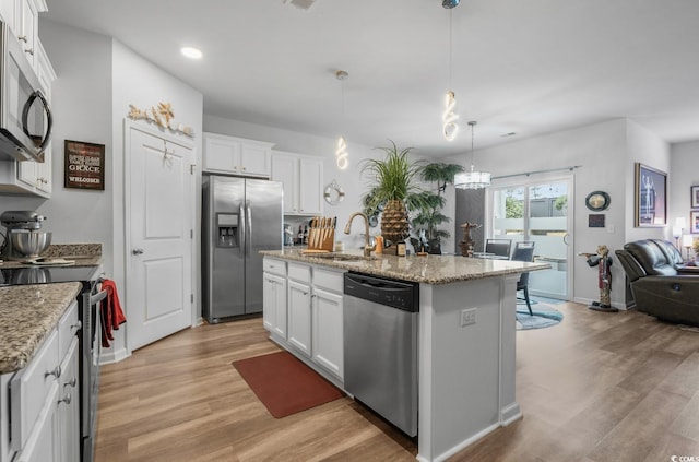 kitchen featuring light wood-style flooring, white cabinetry, stainless steel appliances, and a sink