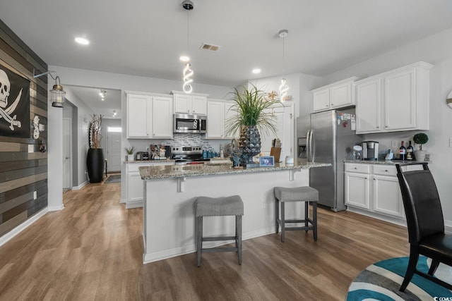 kitchen featuring visible vents, appliances with stainless steel finishes, wood finished floors, and white cabinetry