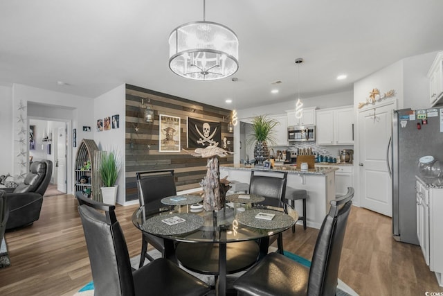dining space with a chandelier, wood finished floors, and recessed lighting