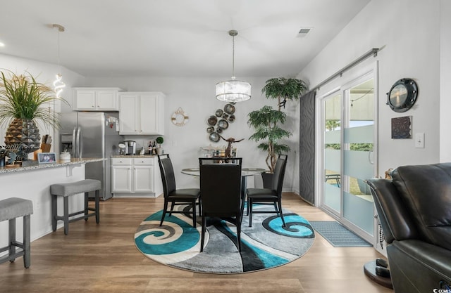 dining space with wood finished floors and visible vents