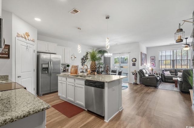 kitchen featuring visible vents, stainless steel appliances, light wood-style floors, white cabinetry, and a sink