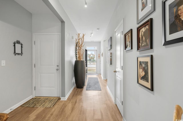 hallway with light wood-style flooring and baseboards