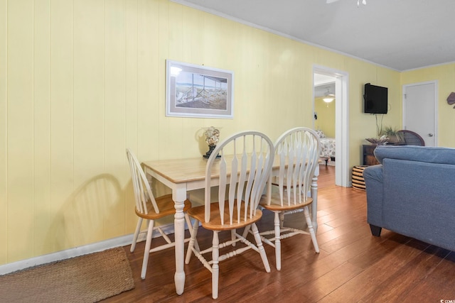 dining area with wood finished floors, ceiling fan, and ornamental molding