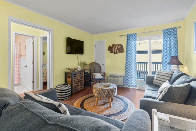 living area with crown molding, wood finished floors, and a wall unit AC